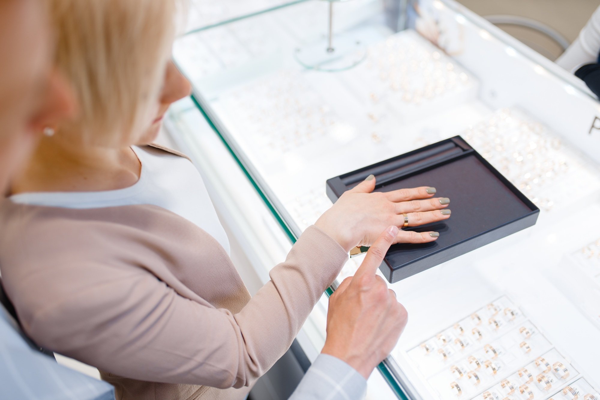 Couple in jewelry store, bride trying on ring