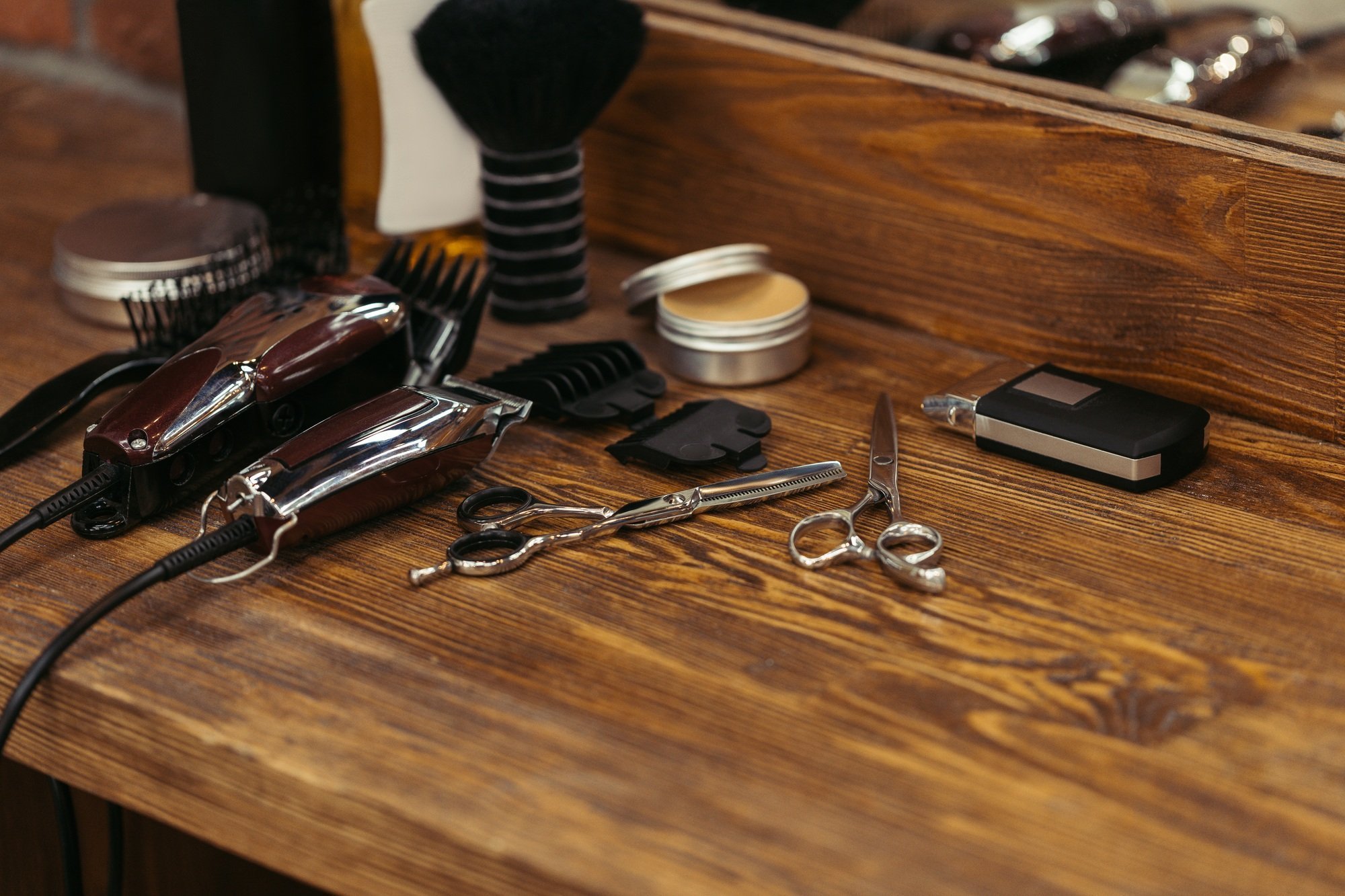 close-up view of various barber tools on wooden shelf in barbershop